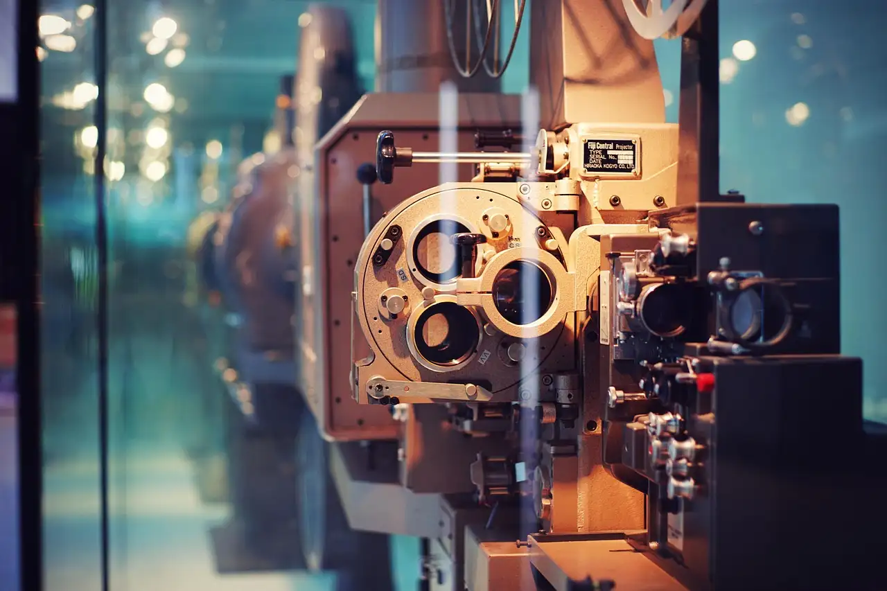 A vintage film projector in a glass display case