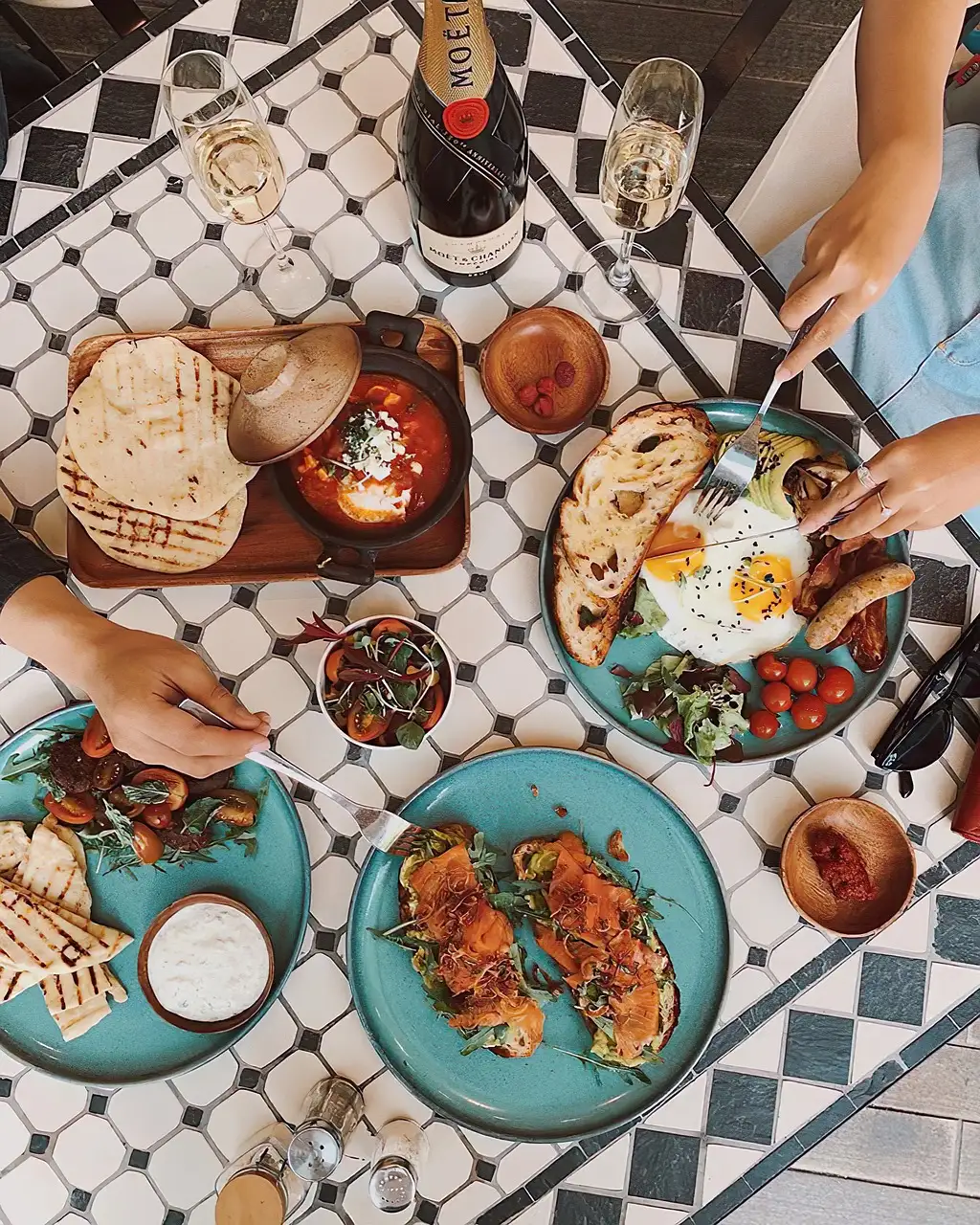 A brunch table with eggs, bread and small plates, seen from above