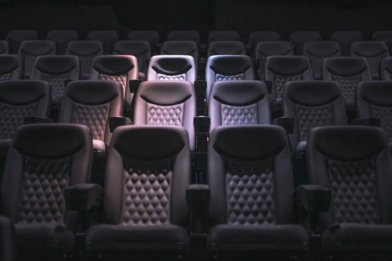 Rows of empty padded seats in a dark movie theater