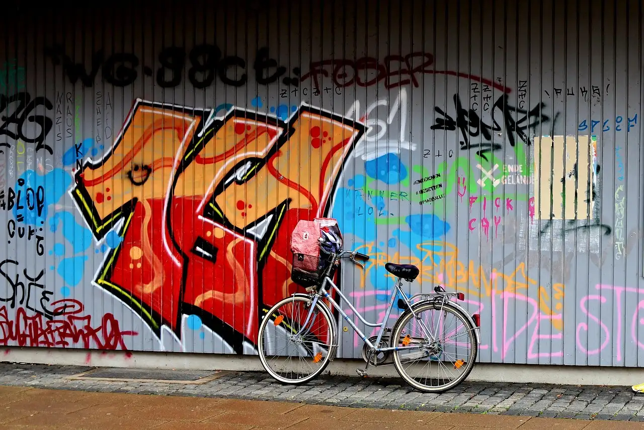 A wall covered in colourful graffiti with a bicycle leaning against it