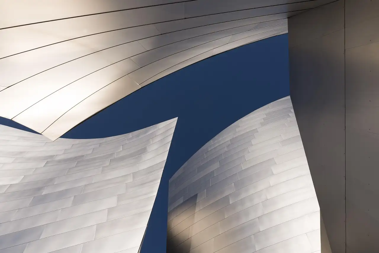 The curved steel walls of Walt Disney Concert Hall against a blue sky