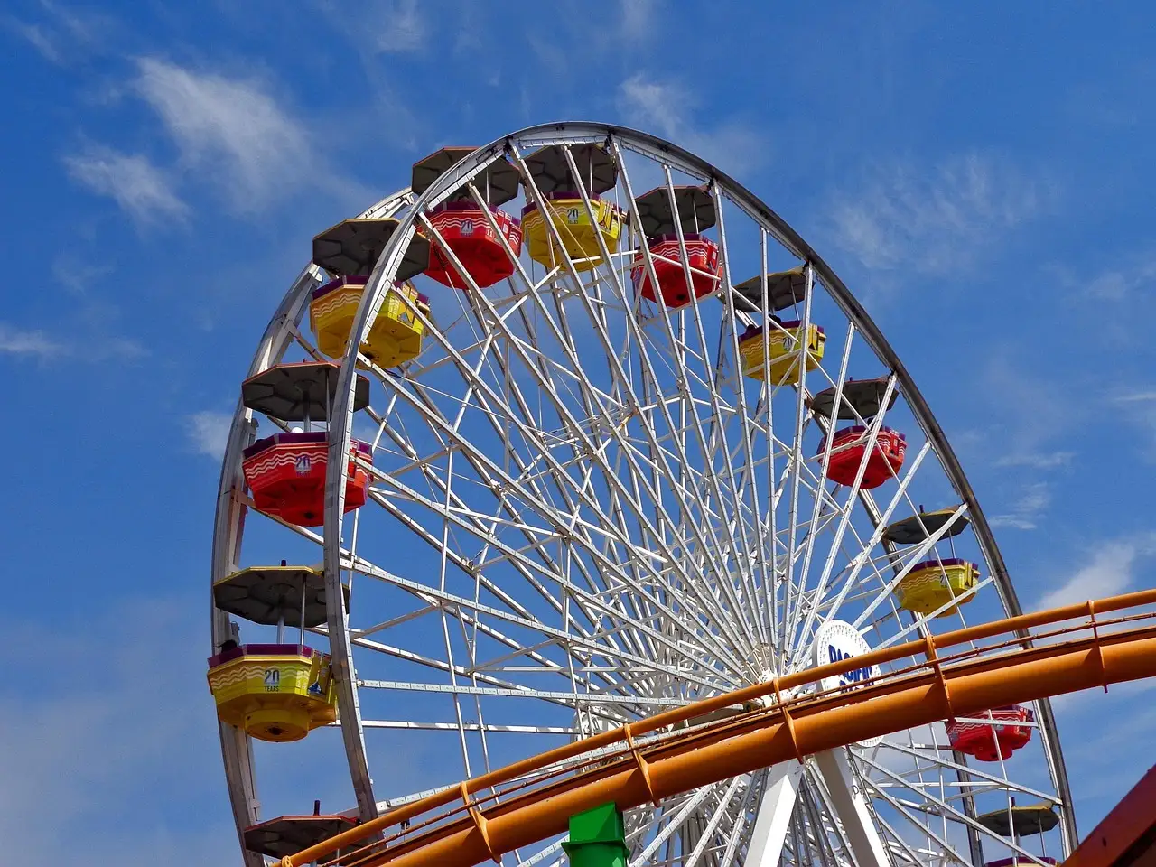 Ferris wheel and roller coaster track at Pacific Park on the Santa Monica Pier