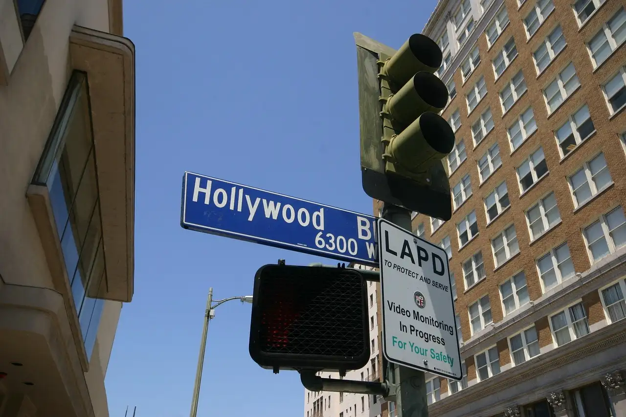 A Hollywood street sign hanging beside a traffic light