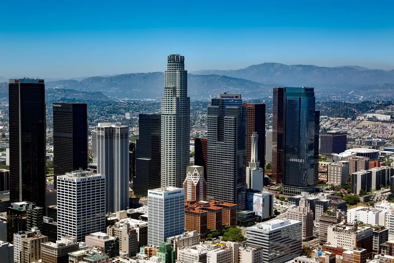 The towers of Downtown Los Angeles seen from above, with mountains behind