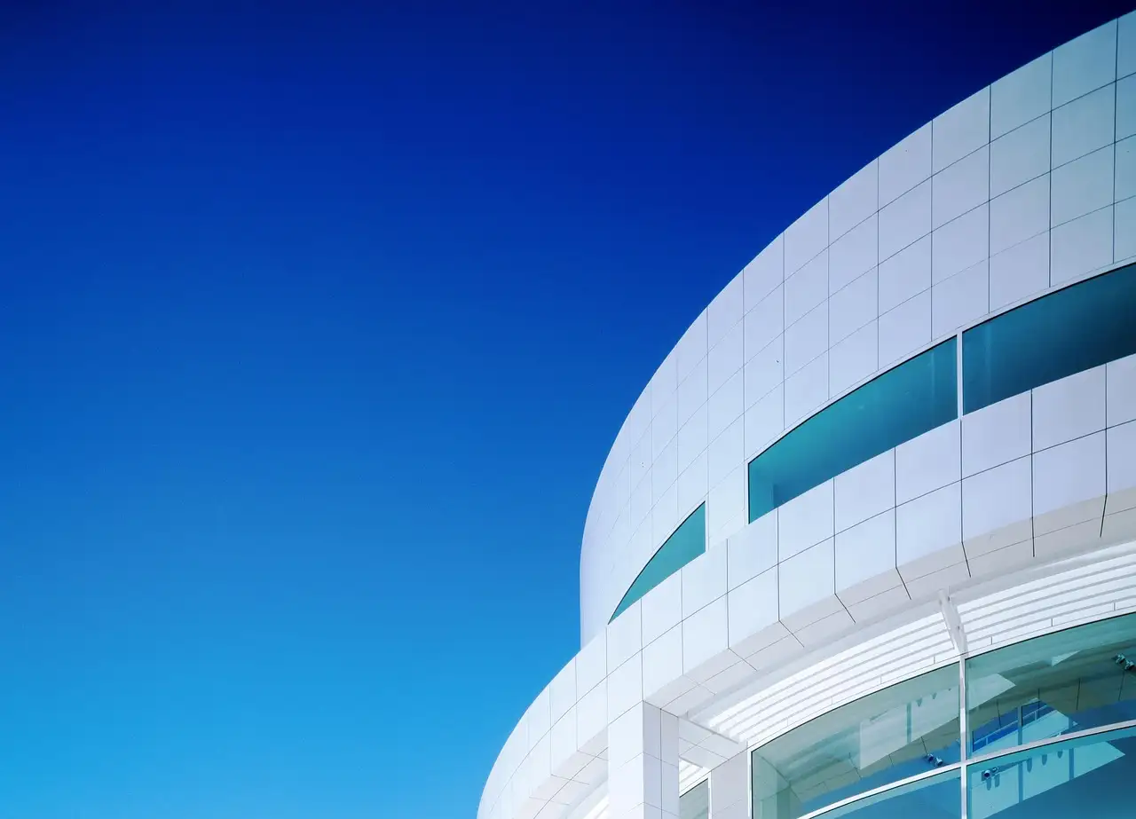 A curved white Getty Center building against a deep blue sky