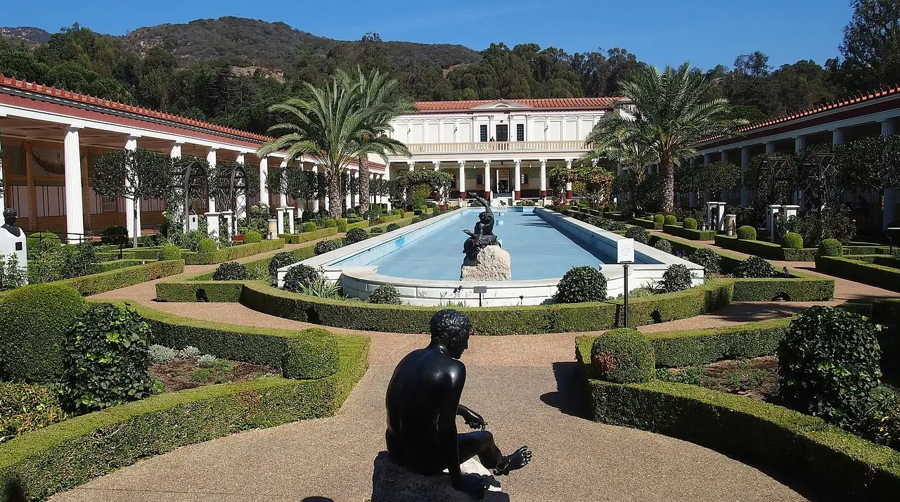 The long pool and formal garden of the Getty Villa, with a bronze statue