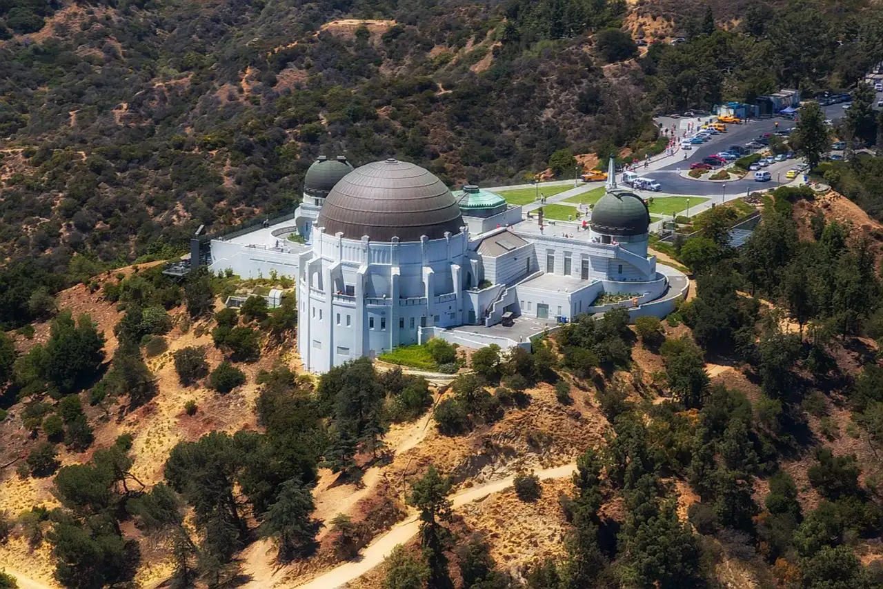 Griffith Observatory seen from above on its hill, surrounded by dry brush