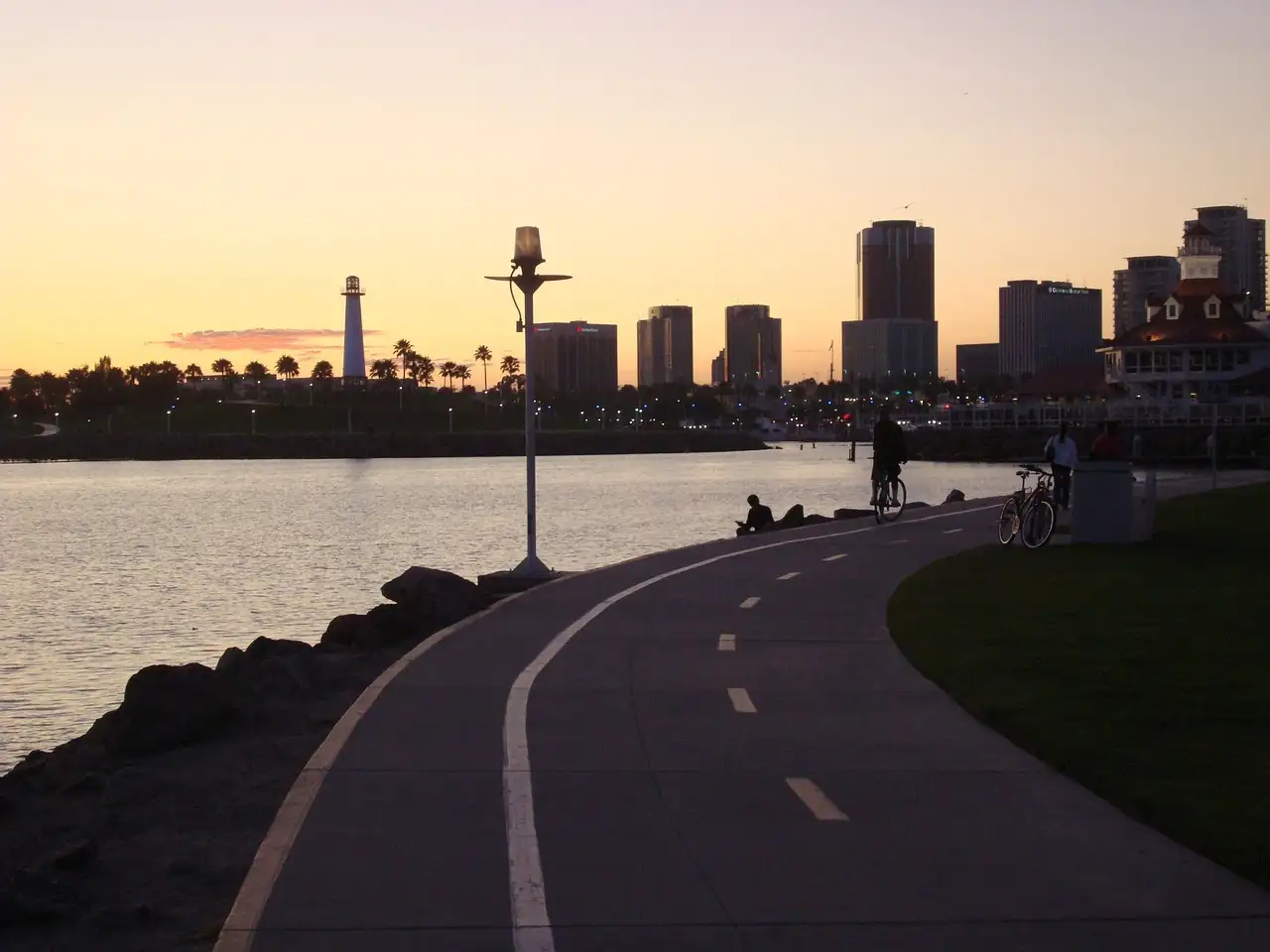 The Long Beach skyline and a white lighthouse across the harbor at dusk