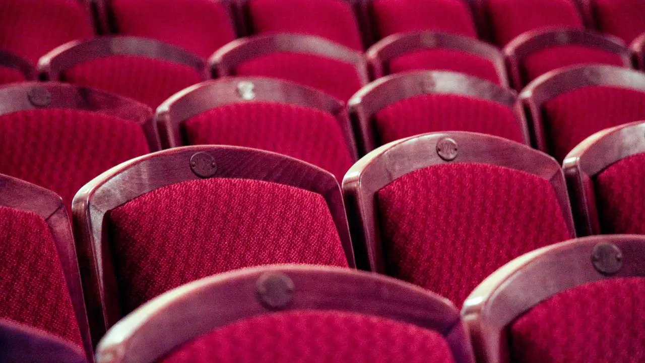 Rows of red upholstered theatre seats