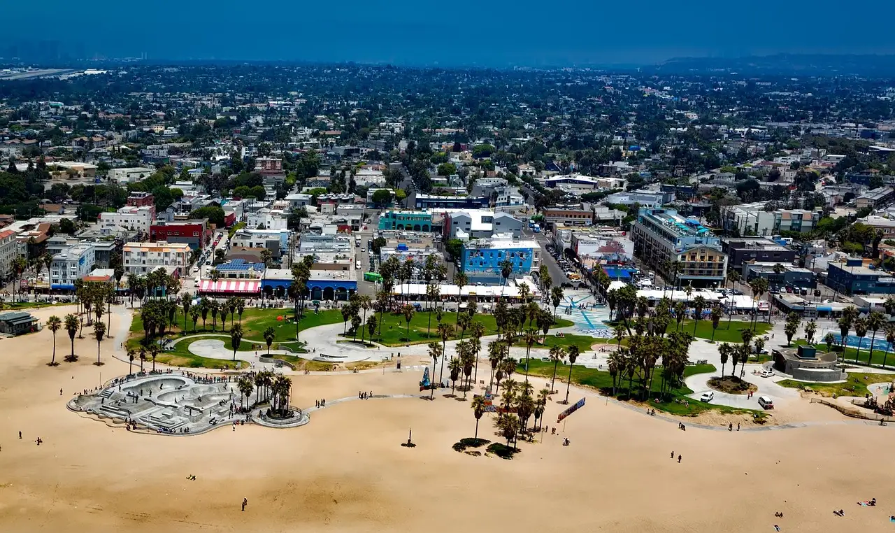 Venice Beach from the air, with the skate park, palm trees and the town behind the sand