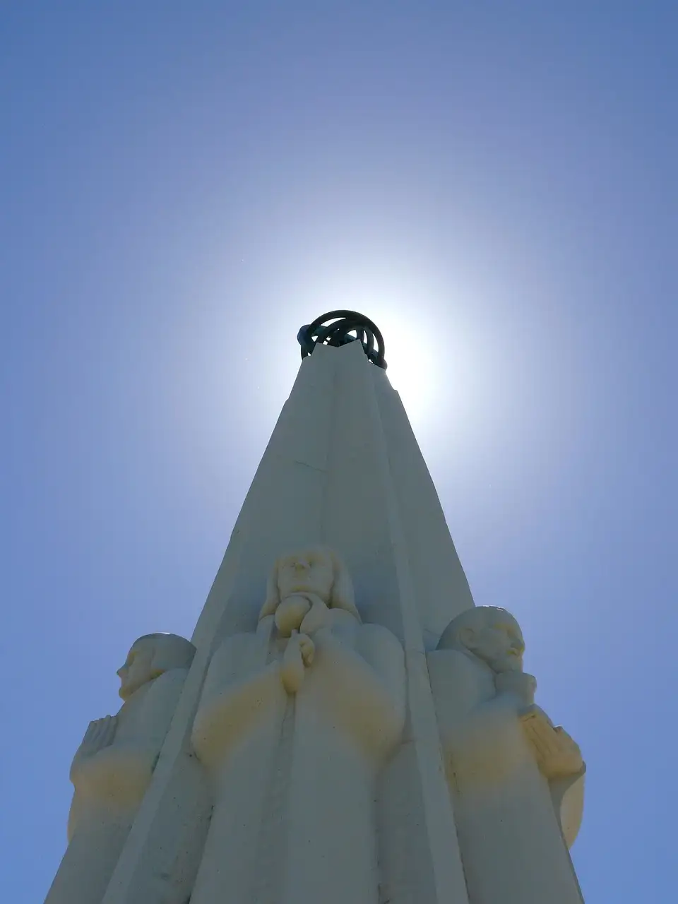 The Astronomers Monument outside Griffith Observatory against a bright blue sky