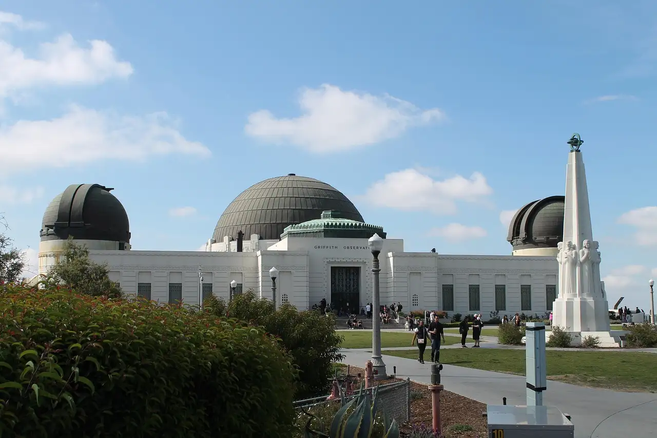 The white building and domes of Griffith Observatory under a blue sky
