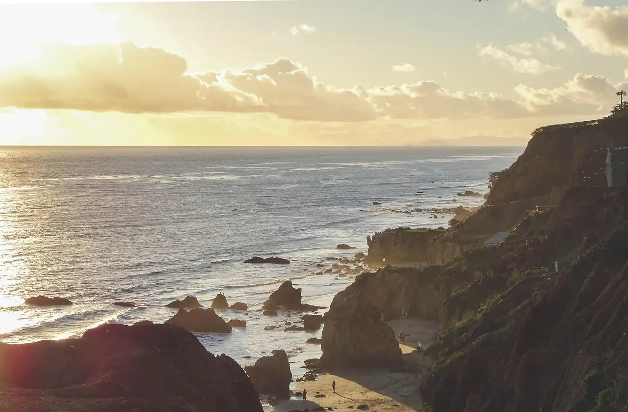 Waves and rocky cliffs on a Malibu beach in low evening sun