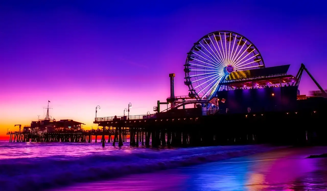 Santa Monica Pier and its Ferris wheel lit up in purple at dusk