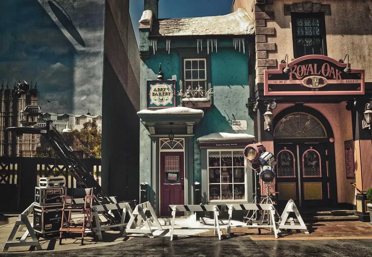 A film-set street of painted shop fronts with studio lights and equipment cases