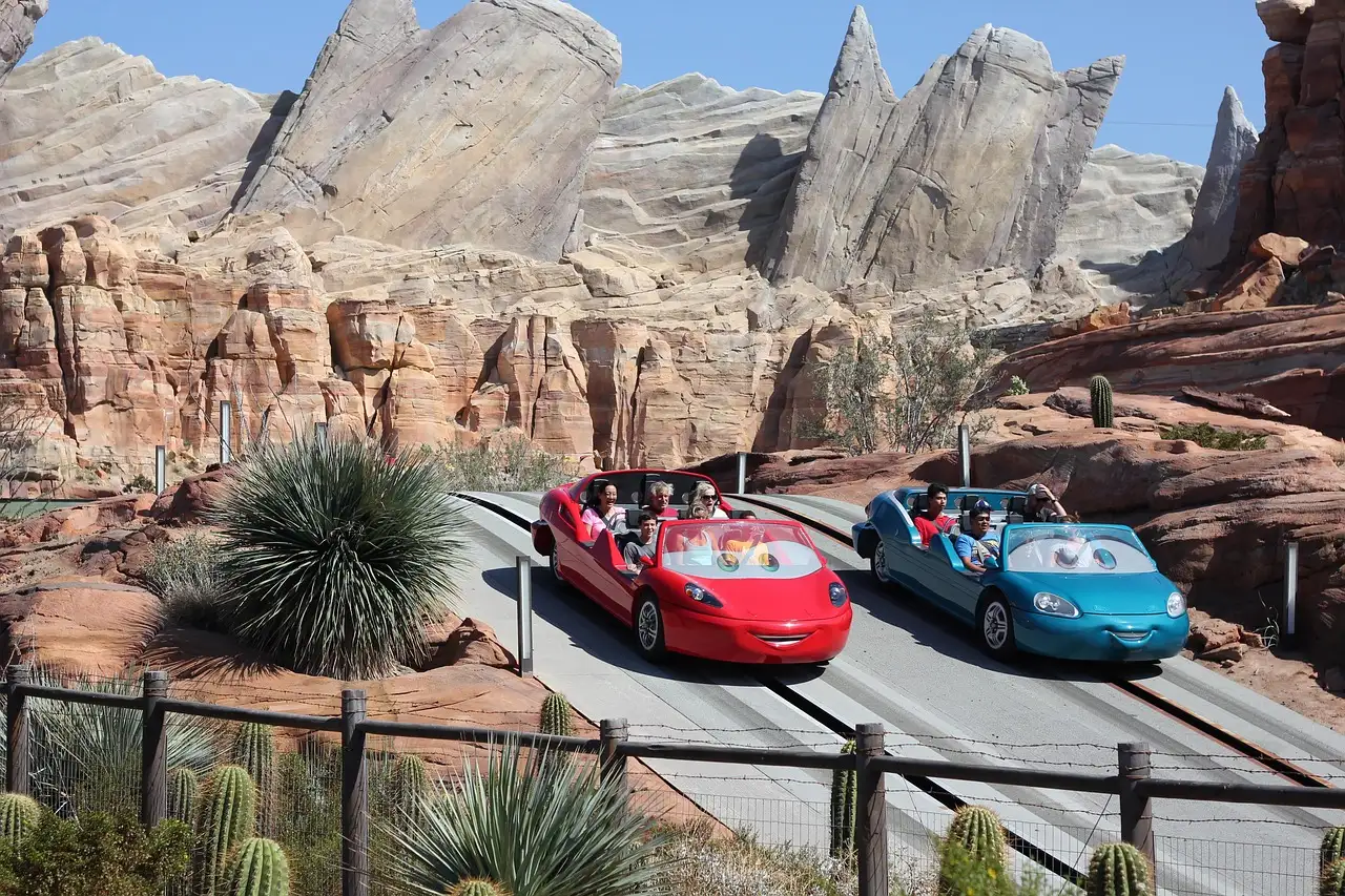 Two ride cars racing through red rock scenery at Cars Land, Disney California Adventure in Anaheim