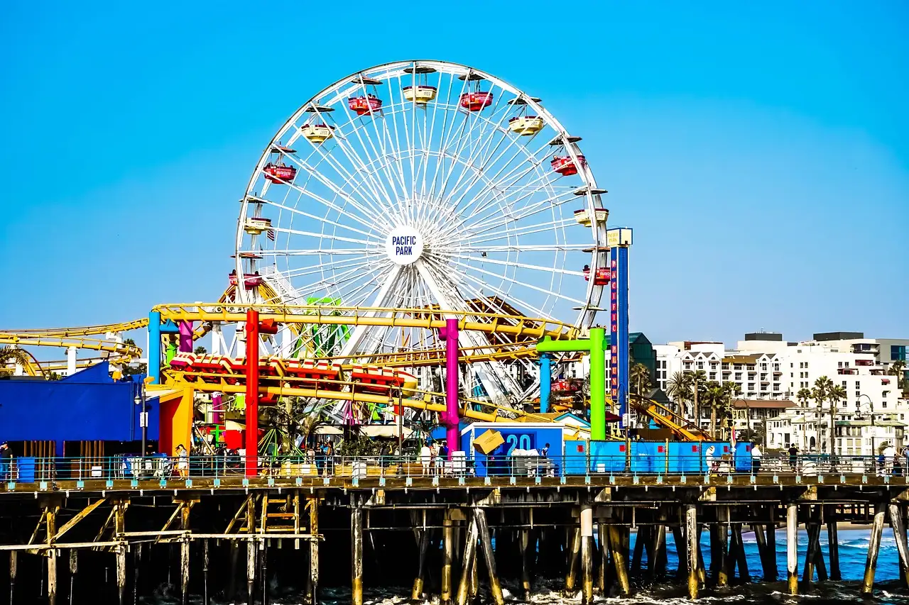 The Ferris wheel and rides on Santa Monica Pier under a blue sky