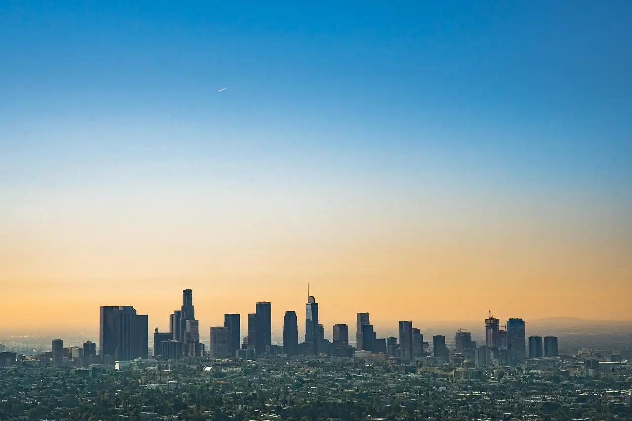 The Downtown Los Angeles skyline under an orange and blue morning sky