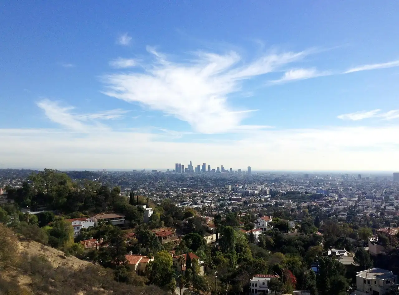 Downtown Los Angeles skyline seen across the city from the hills under a clear blue sky