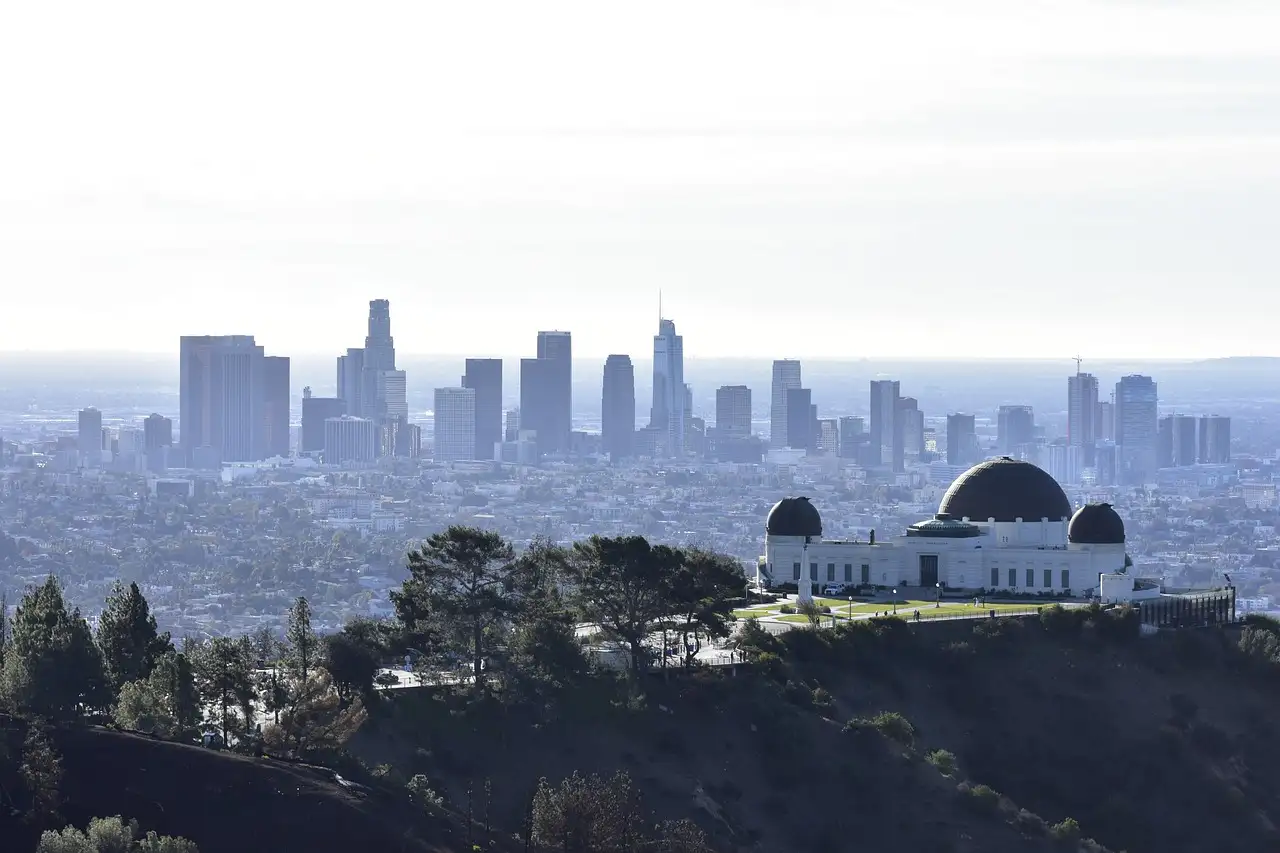 Griffith Observatory on the hillside with the downtown Los Angeles skyline behind