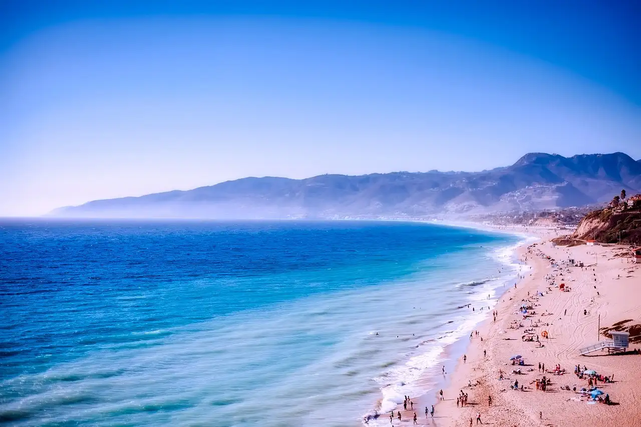 A long sandy Malibu beach with mountains in the distance