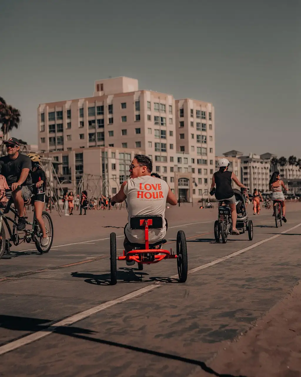 Cyclists riding along the beach path in Venice, seen from behind