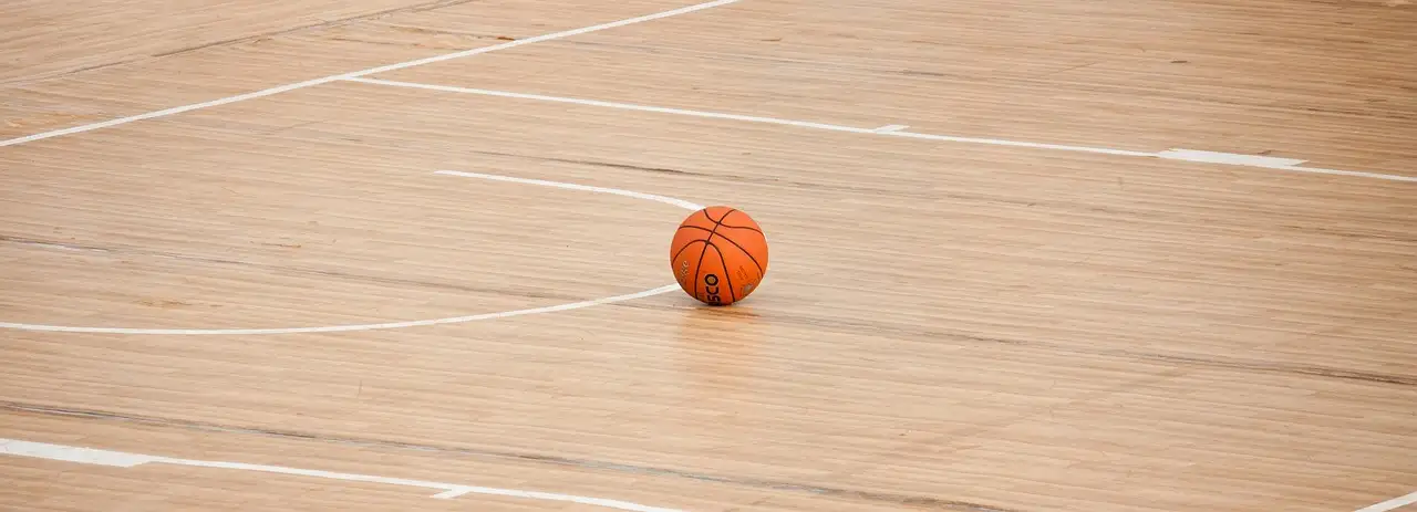 A wooden basketball court floor in an indoor arena