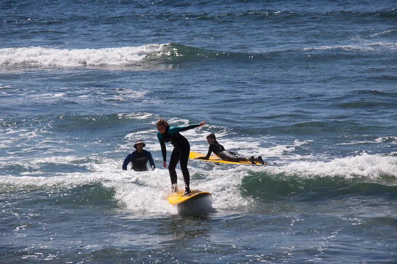Surfers catching a white-water wave close to shore