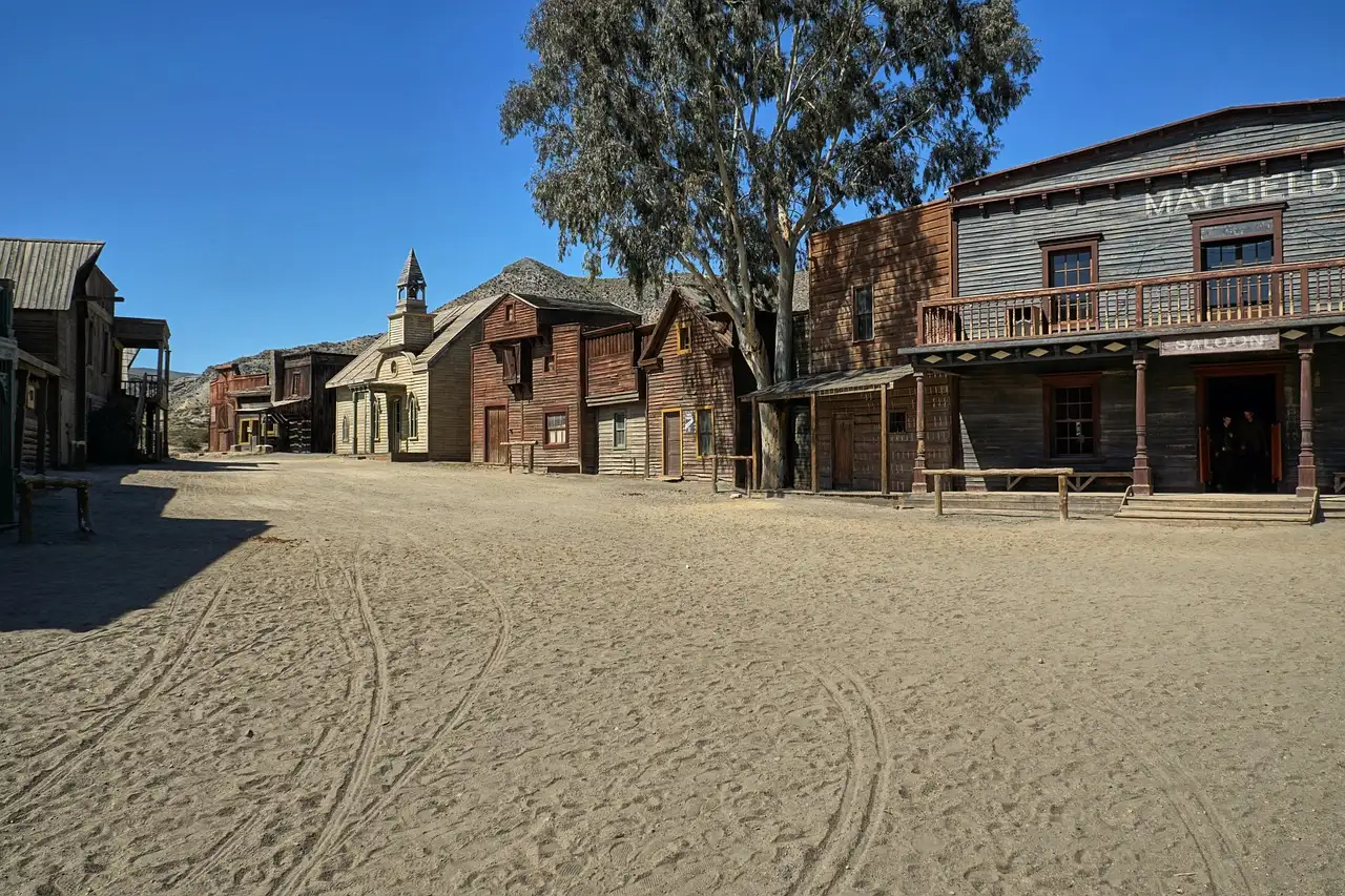 A dusty street of wooden Wild West buildings on an outdoor film set